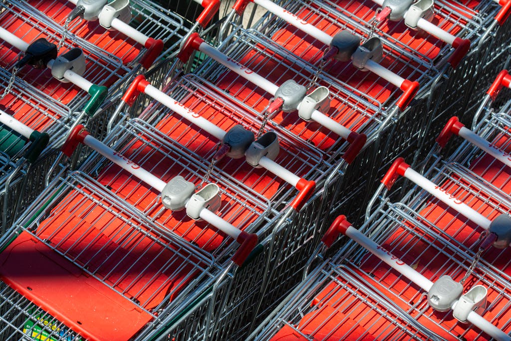12間法國超市大評比!哪間最便宜?最推薦哪一間? 5 Neatly arranged shopping carts casting shadows under bright sunlight, showcasing a supermarket exterior.